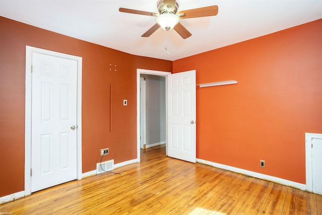unfurnished bedroom with visible vents, a ceiling fan, light wood-style flooring, and baseboards