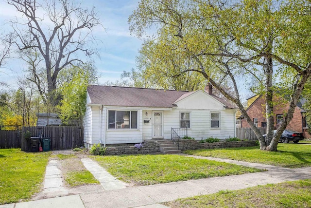 bungalow with fence, a chimney, and a front lawn