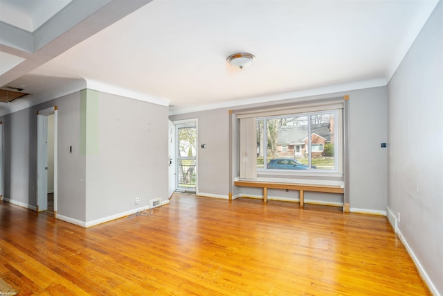 empty room featuring light wood-type flooring, baseboards, and visible vents