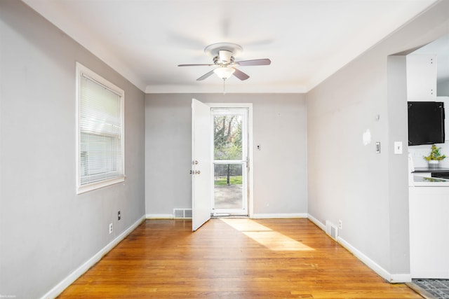 doorway to outside with baseboards, light wood finished floors, and ceiling fan
