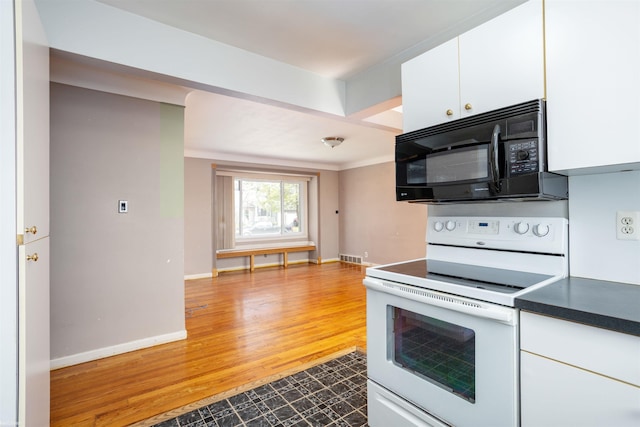 kitchen with black microwave, baseboards, white cabinets, electric stove, and light wood finished floors