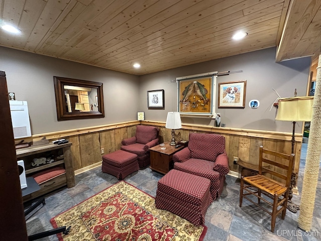 sitting room with stone tile floors, recessed lighting, wood ceiling, and a wainscoted wall