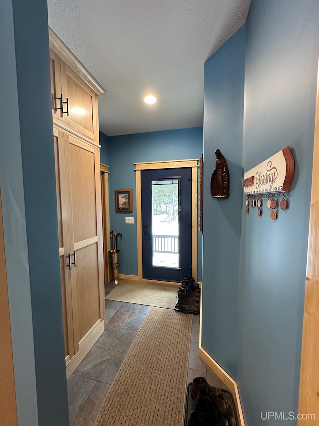 entryway with baseboards and stone finish flooring