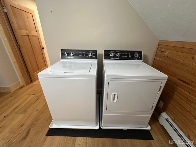 laundry area featuring washing machine and clothes dryer, laundry area, baseboard heating, and light wood-type flooring