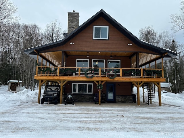 exterior space featuring a chimney, a deck, and stone siding