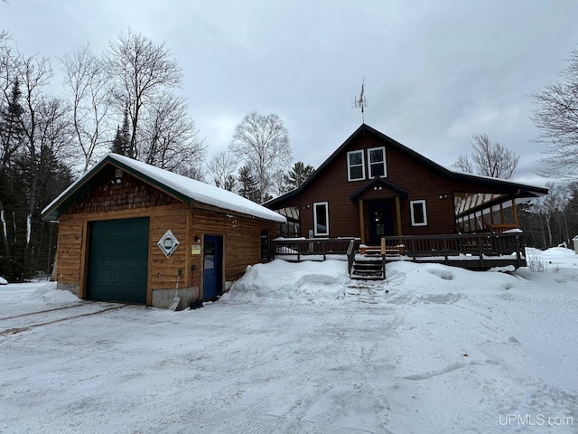 rustic home featuring an outdoor structure, a wooden deck, and a detached garage