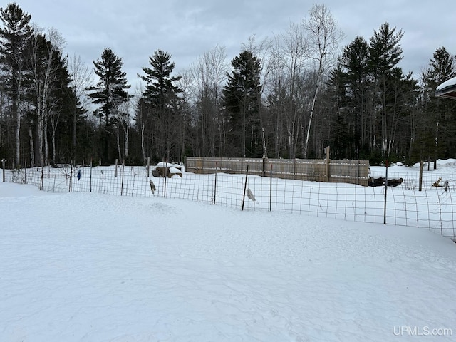 yard covered in snow with fence