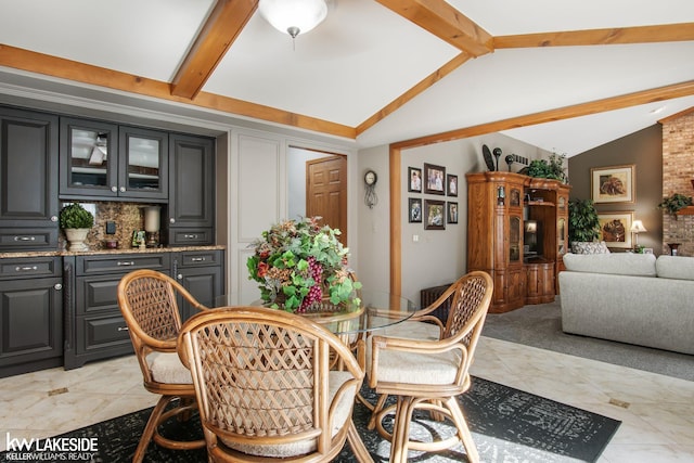 dining room featuring vaulted ceiling with beams and indoor bar