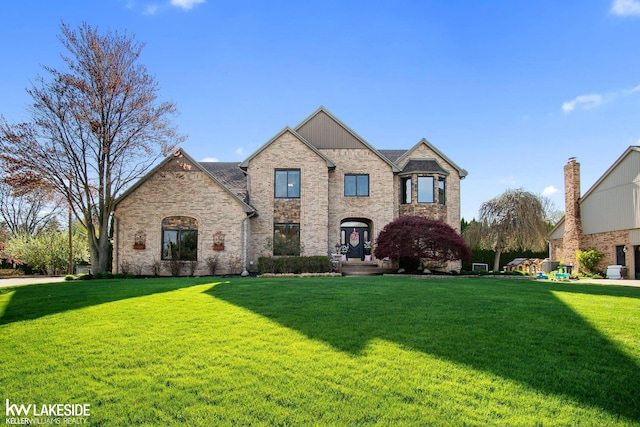 french country inspired facade with brick siding and a front lawn