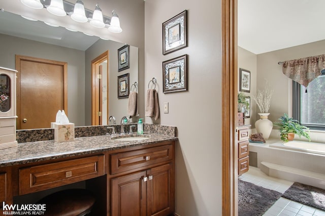 bathroom featuring a garden tub, tile patterned flooring, and vanity