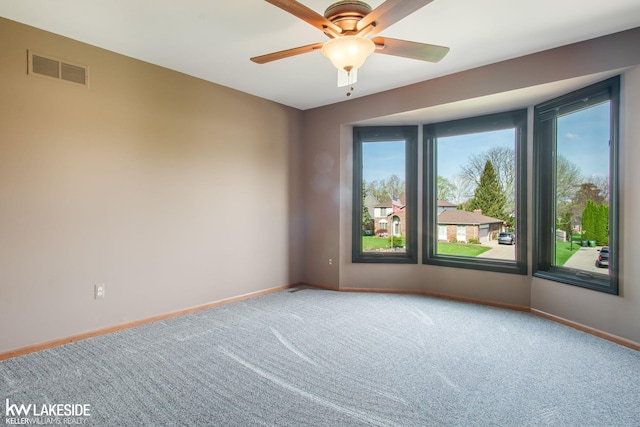 unfurnished room featuring carpet floors, baseboards, ceiling fan, and visible vents