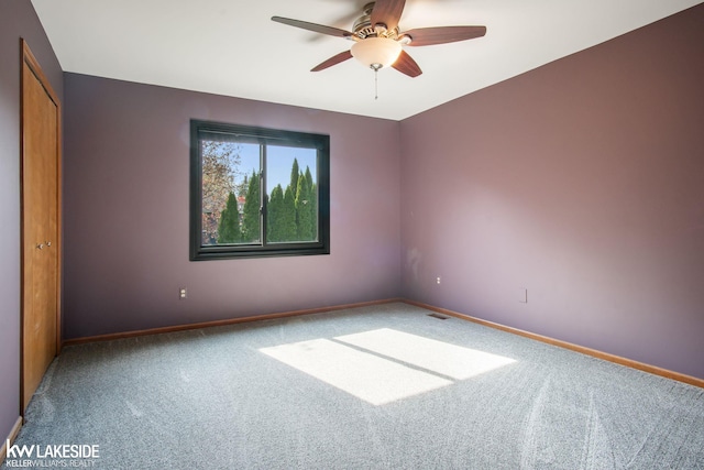 spare room featuring carpet flooring, baseboards, and ceiling fan