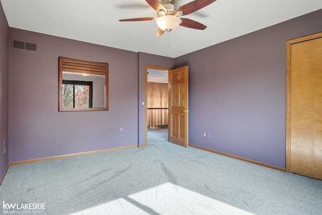 empty room with carpet floors, baseboards, and visible vents