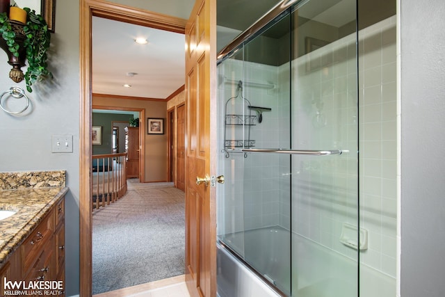 bathroom featuring crown molding, vanity, and bath / shower combo with glass door