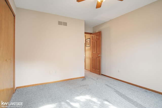 unfurnished bedroom with ceiling fan, light carpet, baseboards, visible vents, and a closet