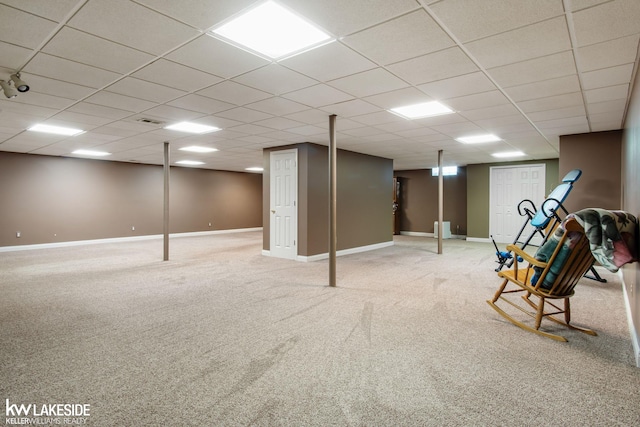 finished below grade area featuring baseboards, carpet flooring, and a paneled ceiling