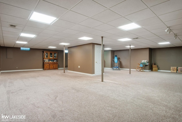 finished below grade area with baseboards, carpet flooring, and a paneled ceiling