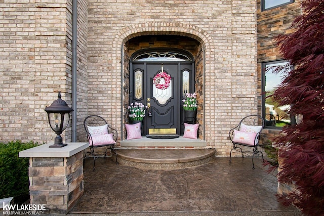 entrance to property featuring brick siding