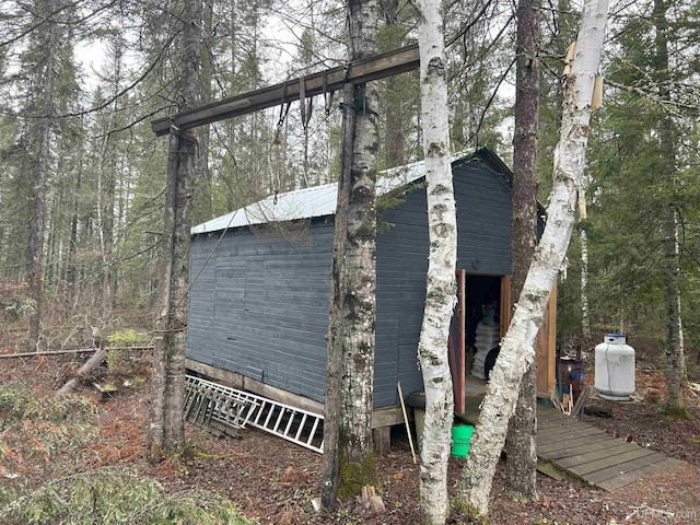 view of outbuilding featuring an outdoor structure and a forest view