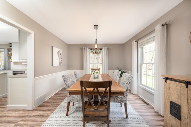 dining room featuring baseboards, visible vents, and light wood-type flooring