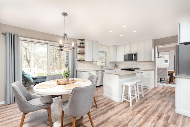 dining room with recessed lighting, a notable chandelier, a wealth of natural light, and light wood finished floors