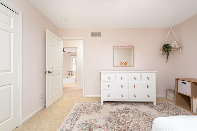 bedroom featuring baseboards, visible vents, and light carpet