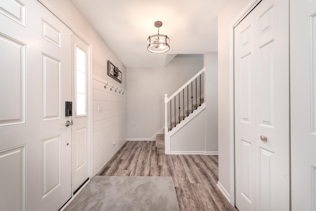 foyer with stairs, baseboards, and wood finished floors