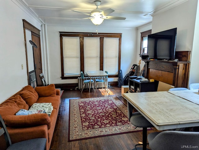 living room featuring baseboards, ceiling fan, wood-type flooring, and ornamental molding
