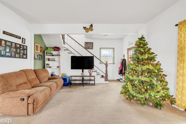 carpeted living area with stairs