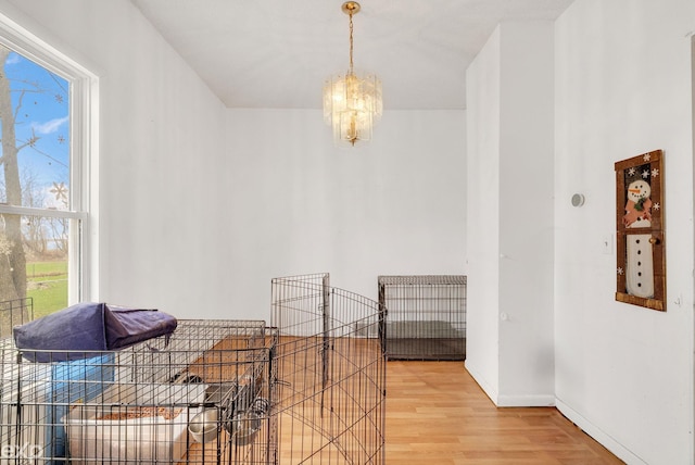 interior space with light wood-style floors, baseboards, and a notable chandelier