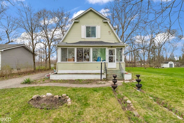 colonial inspired home featuring a sunroom, a shingled roof, and a front yard