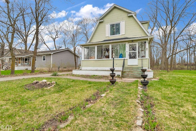 dutch colonial featuring a sunroom and a front lawn