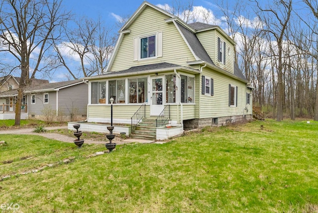 dutch colonial with a sunroom, a shingled roof, a front yard, and a gambrel roof