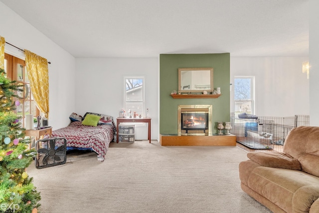 carpeted bedroom with a glass covered fireplace and multiple windows