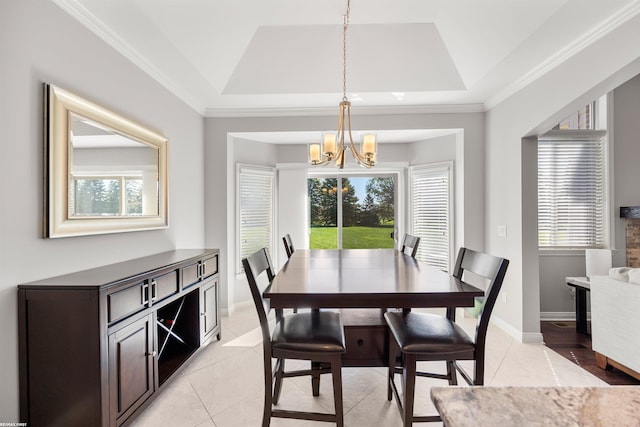 dining area with a healthy amount of sunlight, light tile patterned floors, a tray ceiling, and a notable chandelier