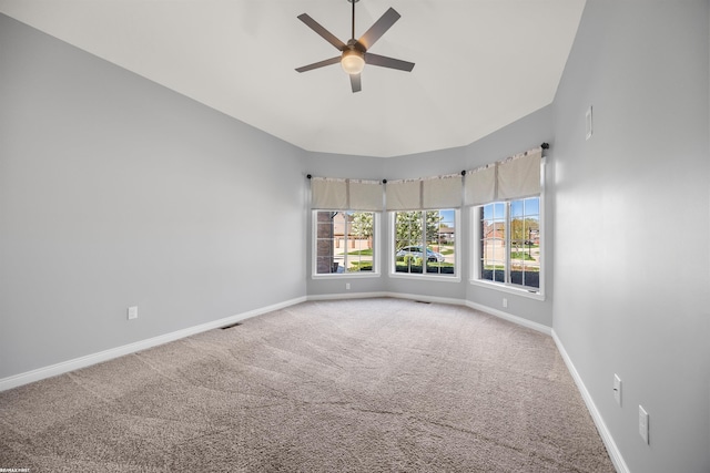 carpeted spare room with baseboards, ceiling fan, and visible vents