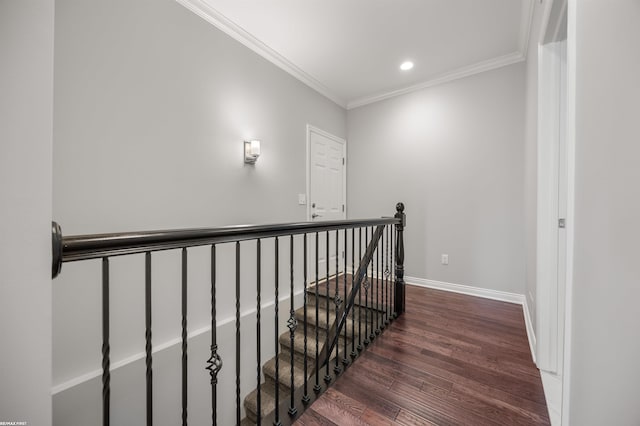corridor featuring recessed lighting, baseboards, an upstairs landing, wood finished floors, and ornamental molding