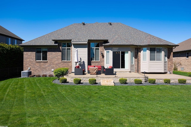 rear view of house with a yard, brick siding, and a patio