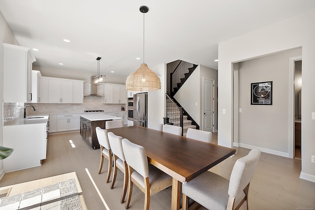 dining room with stairway, baseboards, light wood-type flooring, and recessed lighting
