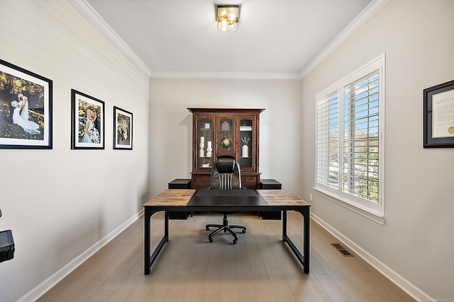 office area with baseboards, a wealth of natural light, wood finished floors, and visible vents