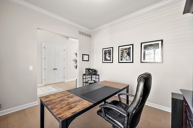 home office with visible vents, ornamental molding, baseboards, and wood finished floors