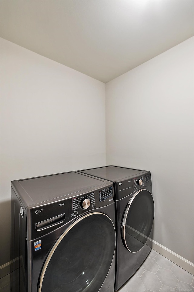 clothes washing area featuring laundry area, baseboards, and separate washer and dryer