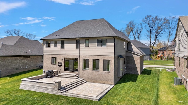 rear view of house with a lawn, a patio, and brick siding