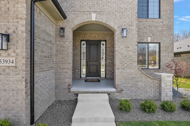 doorway to property with brick siding