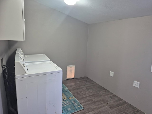 laundry room with dark wood-type flooring, cabinet space, and washer and clothes dryer