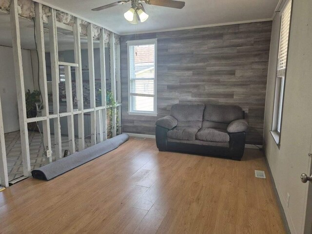 sitting room with crown molding, ceiling fan, and wood finished floors