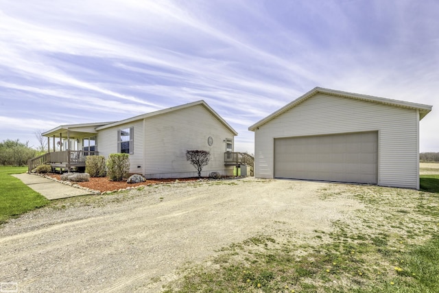 8765 Winn Rd, Brown City, MI 48416 - view of side of property with a detached garage, driveway, covered porch, and an outdoor structure