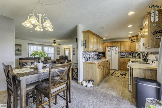 8765 Winn Rd, Brown City, MI 48416 - kitchen featuring white appliances, recessed lighting, light countertops, ceiling fan with notable chandelier, and backsplash