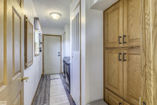 8765 Winn Rd, Brown City, MI 48416 - clothes washing area featuring cabinet space, light wood-style floors, separate washer and dryer, a heating unit, and a textured ceiling