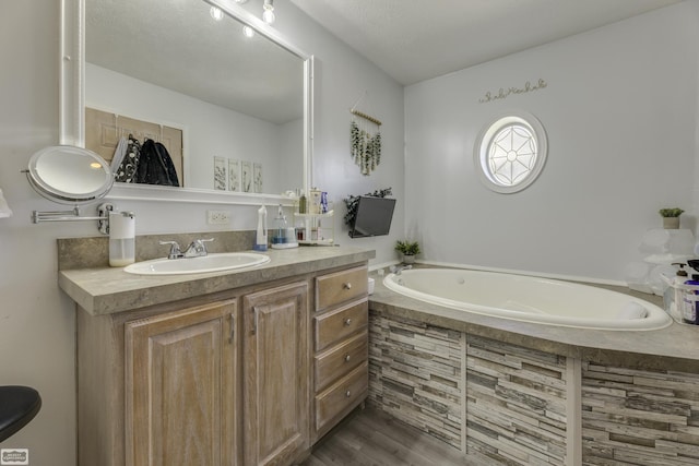 8765 Winn Rd, Brown City, MI 48416 - full bathroom featuring vanity, a garden tub, and wood finished floors